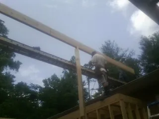 Carpenter setting a ridge beam over a new addition frame — Ice Dam Removal by Roofing Brothers in Catawba