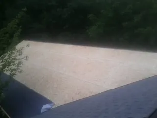 New OSB roof sheathing installed beside an existing shingle roof in Catawba