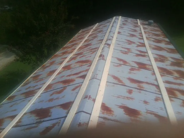 Rusted metal roof panels with new wood purlins before replacement — Storm Damage Roof Repair in Catawba by Roofing Brothers