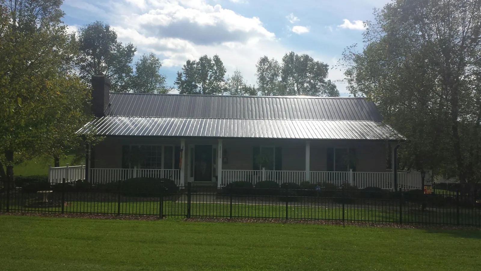 Gray metal roof on a brick ranch with a full width front porch — Gutter Guard Installation work by our crew in Catawba